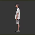 Young boy standing wearing white T-shirt gray shorts and gray shoes on gray gradient background