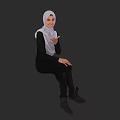 Woman in Black Dress With White Hijab Sitting and Gesturing Against Dark Background
