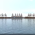 Fully Loaded Container Ship Sails Near Busy International Commercial Seaport With Large Port Gantry Cranes
