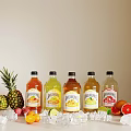 Assorted Fruit Juices Display with Fresh Fruits and Ice Cubes