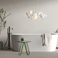 Modern White Bathtub with Cloud Shaped Pendant Light Green Side Table Hanging Towel and Plant
