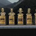 Detailed Bronze Figure Bust Sculptures With Inscribed Bases Against Mountain Forest Landscape