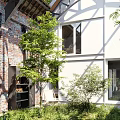 Serene Courtyard Garden With Red Brick Walls Glass Roof White Building And Stone Path