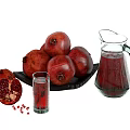 Pomegranate Juice in Glass Pitcher with Fresh Whole Sliced Pomegranates and Seeds