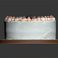 Delicious Decorated White Cream Cake With Purple Top Cream Flowers And Chocolate Decoration On Brown Tray