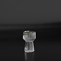 Transparent Wine Bottle And Gold Rimmed Wine Glass With Vertical Stripes On Black Surface