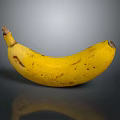 Ripe Yellow Banana With Brown Spots On Smooth Reflective Surface