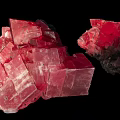 Vibrant Red Pink Rockery Stones With Crystal Structure And Shiny Surface On Black Background