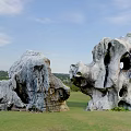 Unique Shaped Stone Garden Ornaments On Green Grassland With Blue Sky And Distant Hills