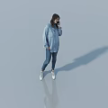 Woman Standing In Light Background Talking On Phone Wearing Blue Shirt Jeans And White Shoes
