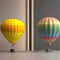 Yellow Orange Striped and Multicolored Hot Air Balloons Displayed on Gray Tabletop