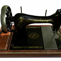 Vintage Industrial Sewing Machine Featuring Black Metal Components Wooden Base And Golden Decorative Patterns