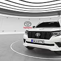 Toyota White SUV With Black Wheels Displayed In Modern Showroom Interior