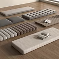 Various Rectangular Fabric Floor Cushions In Different Colors On Wooden Floor With Books