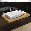 White Washbasin on Wooden Countertop with Faucet Small Bottles and Towel Against Black Tiled Wall