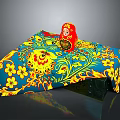 Table with Blue Yellow Floral Tablecloth and Traditional Red Matryoshka Doll
