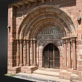 Romanesque Entrance Gate With Red Brick Structure Carved Archway Stone Columns And Wooden Doors