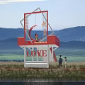 Red Observation Deck With LOVE Signage Mountain Waterfront Grassland View