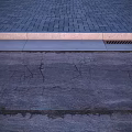 Urban Road Infrastructure Featuring Paved Surface Concrete Curb And Metal Drainage Grate