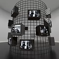 Art Installation Featuring Wire Mesh Cylinder Multiple TV Screens Black And White Images Person Pointing