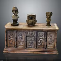 Antique Wooden Cabinet Featuring Carved Designs With Two Small Busts And Pottery Jar On Top