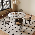 Round Marble Dining Table Set With Four Chairs And Decorative Items On Black White Rug