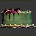 Green Frosted Cake Featuring Pink Decorations Black Berries White Piped Edges and Yellow Bottom Trim