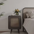 Dark Rattan Panel Bedside Table With Vase Flowers And Cup In Bedroom
