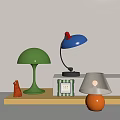 Stylish Table Lamps in Green Blue and Orange on Yellow Shelf with Small Red Decor