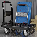 Black Platform Trolley With Gold Wheels Blue Board And Cardboard Boxes
