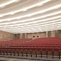 Modern Conference Room With Stepped Red Seats Wooden Walls And Ceiling Lighting