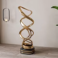 Gold Twisted Metal Sculpture With Spiral Design And Black Striped Base In Interior