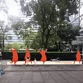 Red Animal Shaped Outdoor Chairs in Urban Park with Trees People Sitting and Kids Playing
