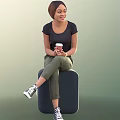 Woman Sitting On Dark Cube Holding Coffee Cup In Black T-Shirt Green Pants White Sneakers