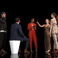 Group of People Socializing in Stylish Outfits With White Stool and Phone Interaction