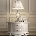 Lace Shade Lamp with Silver Base on White Nightstand and Photo Frames Against Paneled Walls