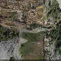 Aerial View Of Steep Rocky Terrain With Lush Green Vegetation And Path Near Water