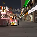 Vibrant Commercial Street At Night With Shops Pedestrians And Outdoor Seating
