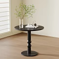 Black Round Side Table With Clear Vase Green Plant And Headphones Indoors