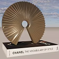 Chanel The Vocabulary of Style Book With Golden Decorative Sculpture On Wooden Floor