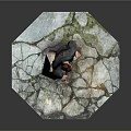 Man in green jacket brown pants standing one foot on rock on hexagonal cracked platform