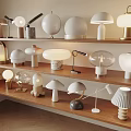 Collection Of Modern Table Lamps With Various Shapes And Materials On Wooden Shelves