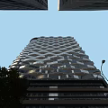 Modern Towering Office Building With Geometric Lattice Facade And Surrounding Street Lamps Trees