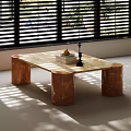 Marble Coffee Table With Copper Cylindrical Legs In Sunlit Room With Window Blinds And Books
