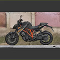 Sporty Black and Orange Motorcycle Displayed On Gray Platform With Red Pink Wall Background