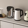 Modern Kitchen Countertop With Stylish Electric Kettles And Mugs On White Cabinets
