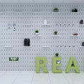 Pegboard Wall Decor With White Shelves Green Plants And READ Letters