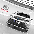 Toyota Silver MPV Car Displayed In Modern Showroom With Logo Background