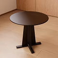 Black Round Side Table With Smooth Surface On Wooden Floor And Cabinet Background