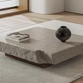 Natural Gray Stone Coffee Table With Stacked Books And Black Vase On Light Rug
